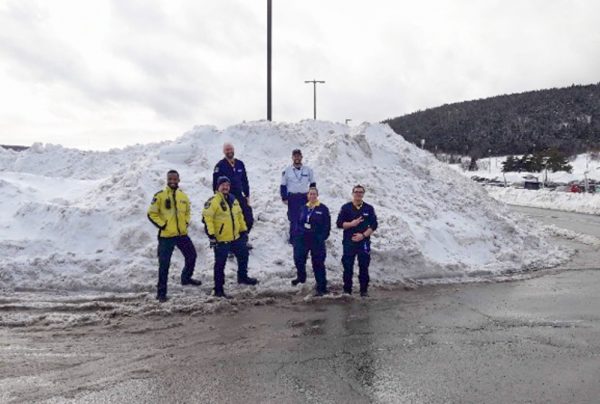 Security Guards Standing on Snow Pile