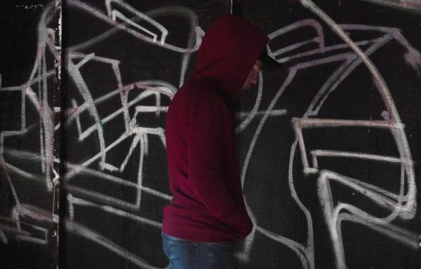 Guy in Hoodie against Grafitti