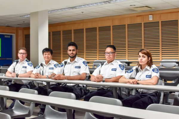 Five Security Guards Sitting at Desk